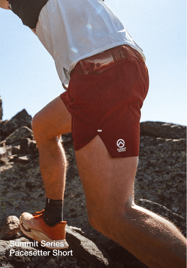 close up of men hiking up boulders wearing pacesetter shorts 