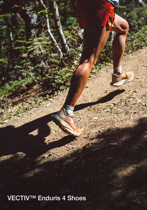 close up shot of woman running in enduris 4 shoes on a trail.