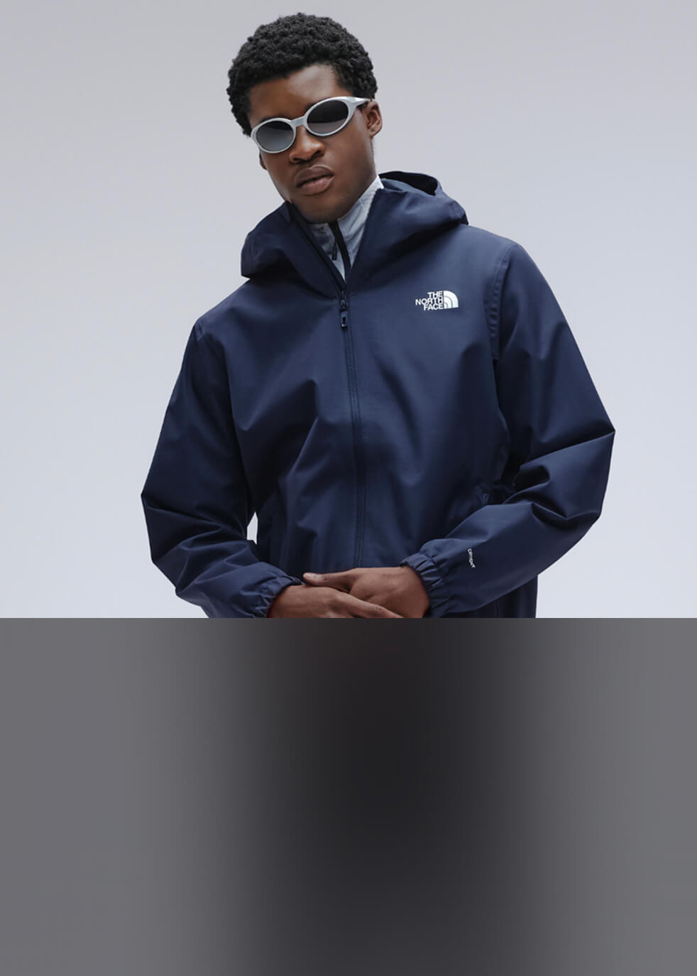 Un homme portant une veste Quest The North Face bleue.