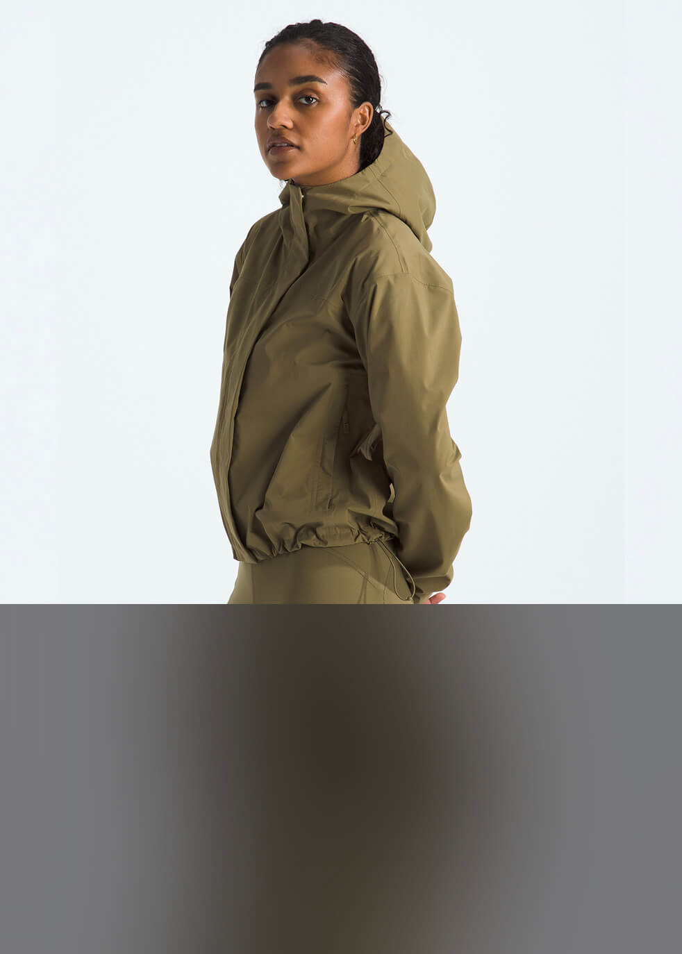 Un homme portant l’imperméable à capuchon Voyage Rain 3L de The North Face.