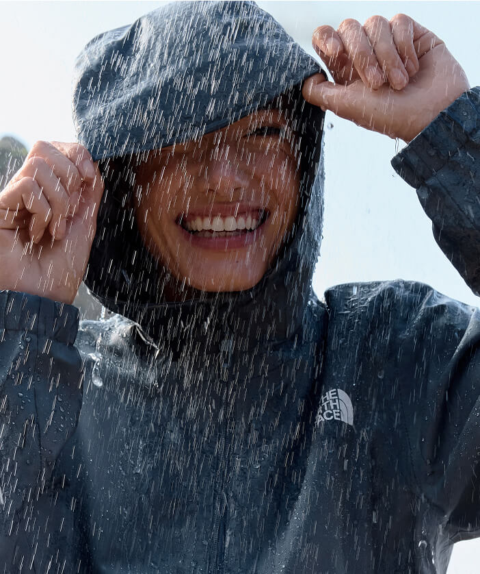 Woman wears dark jacket in the rain.