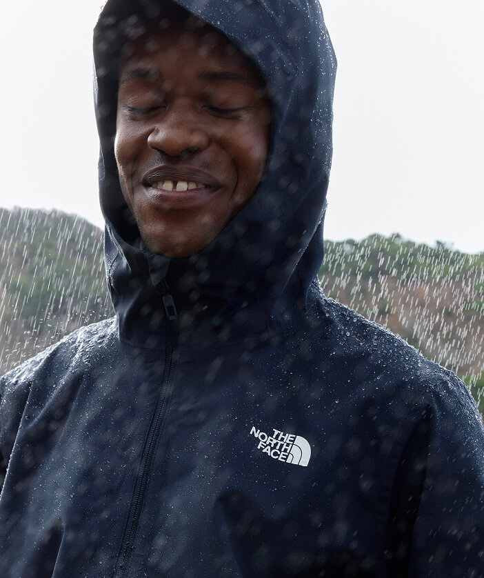 Man wears dark jacket in the rain. 