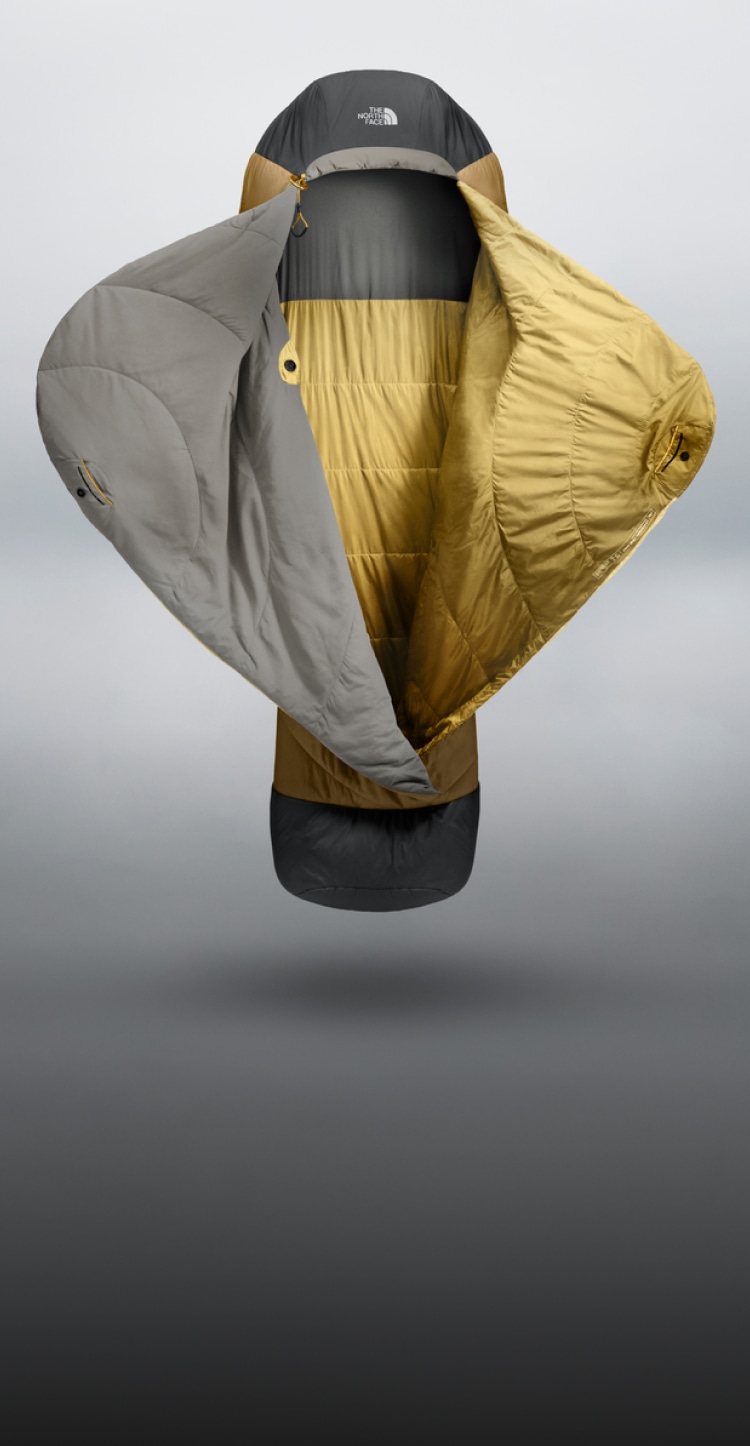 Sac de couchage Universal One Bag, placé debout verticalement avec les rabats ouverts, donnant l’impression qu’il veut vous faire un câlin.