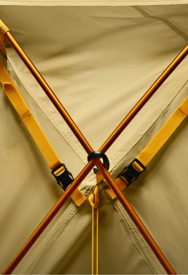 Closeup of tent poles on yellow tent.