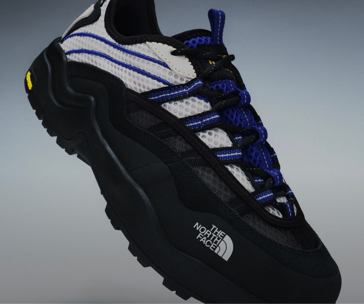 Floating product image of The North Face Clyffe Ultra Shoe in Desert Stone and TNF Blue.