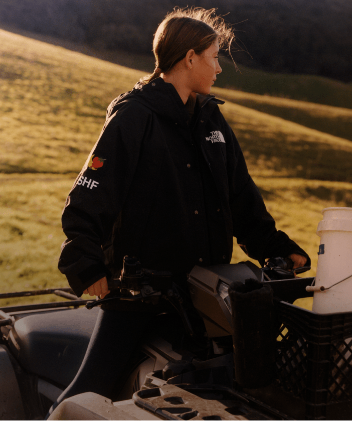 girl in black north face x sky high farm goods hood looking out in a field.