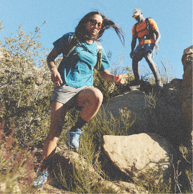 Two trail runners running down a mountain