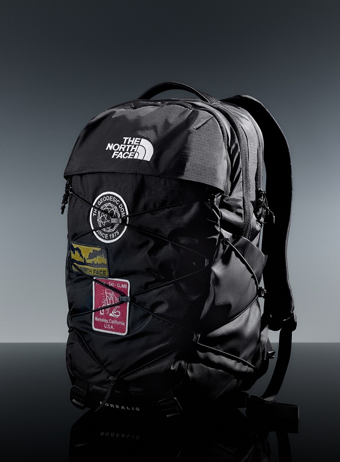 Black Borealis Backpack with patches sitting in a studio setting.