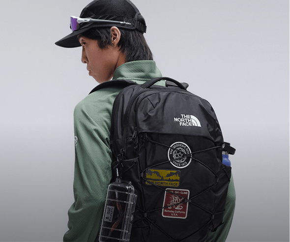 Person standing in a studio wearing a black Borealis backpack.