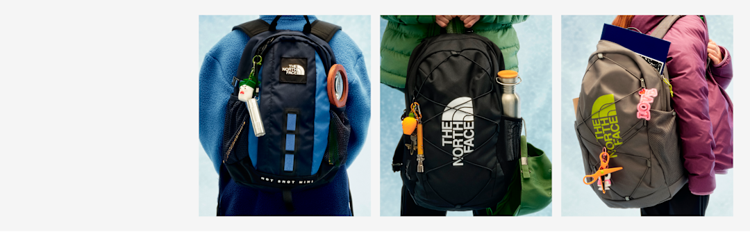 Three young people with their backs to the camera, all wearing backpacks. 