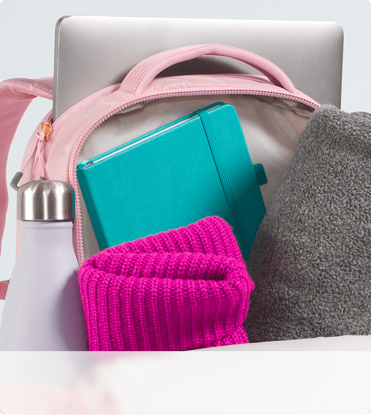 Closeup of a pink backpack’s storage capacity. Zipper open, main compartment exposed.