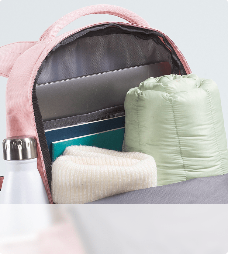 Closeup of a pink backpack’s storage capacity. Zipper open, main compartment exposed.