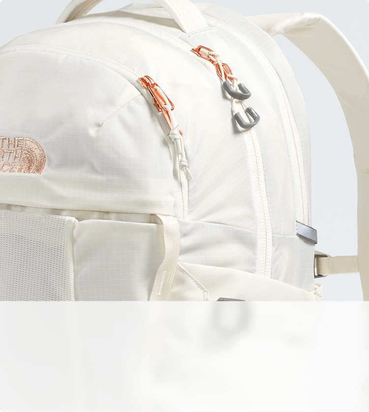 Closeup of metallic accents on a white backpack.
