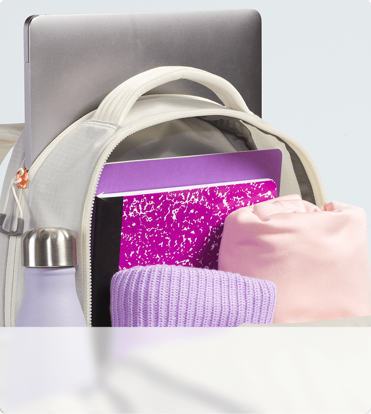 Closeup of a white backpack’s storage capacity. Zipper open, main compartment exposed.