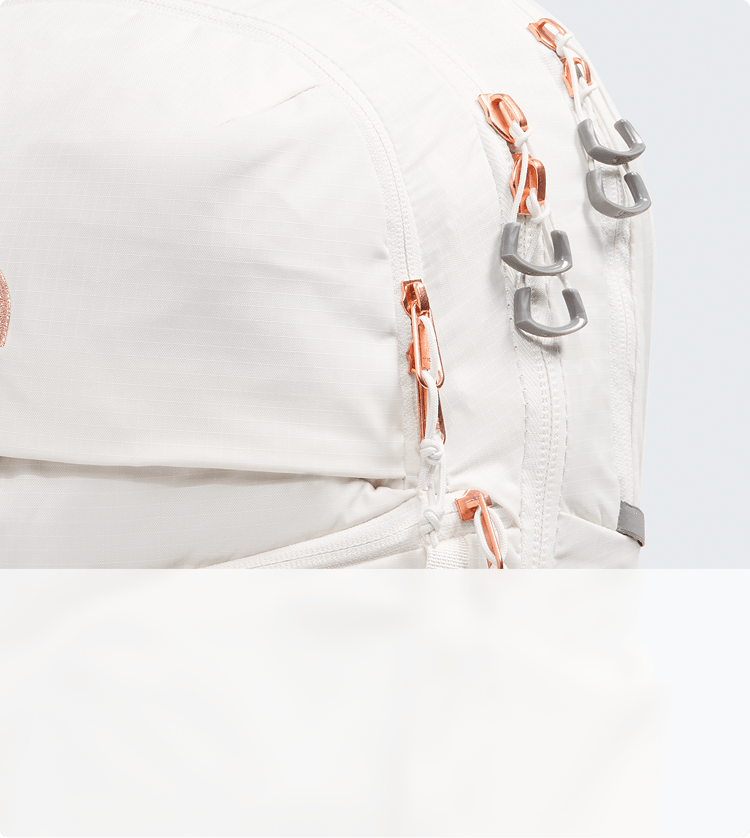 Closeup of metallic accents on a white backpack.