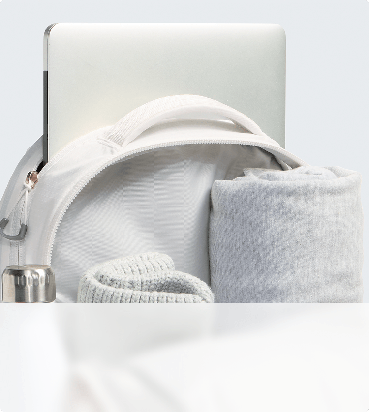 Closeup of a white backpack’s storage capacity. Zipper open, main compartment exposed.