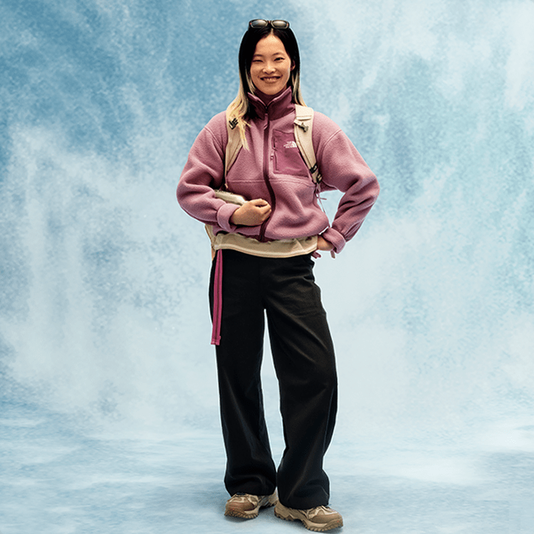 Jeune personne portant un chandail en polar mauve et un pantalon noir.