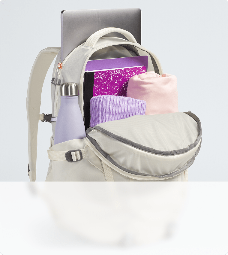 Gros plan sur la capacité de rangement d’un sac à dos blanc. Fermeture à glissière ouverte, compartiment principal visible.