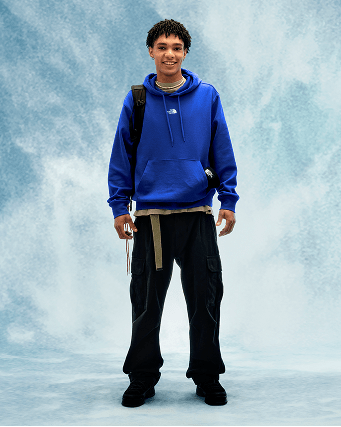 Young person wearing a blue hoodie and black pants