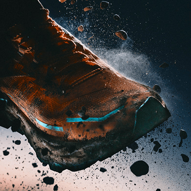 Front of the Offtrail Ultra shoe, suspended in mid-air, rocks flying off it.