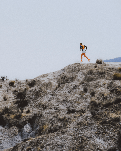 Closeup of a trail run shoe kicking dust behind it.