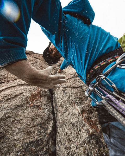 Athlete Matt Cornell setting up climbing gear on a boulder.