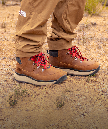 Une paire de bottes de randonnée sur un sentier de terre.