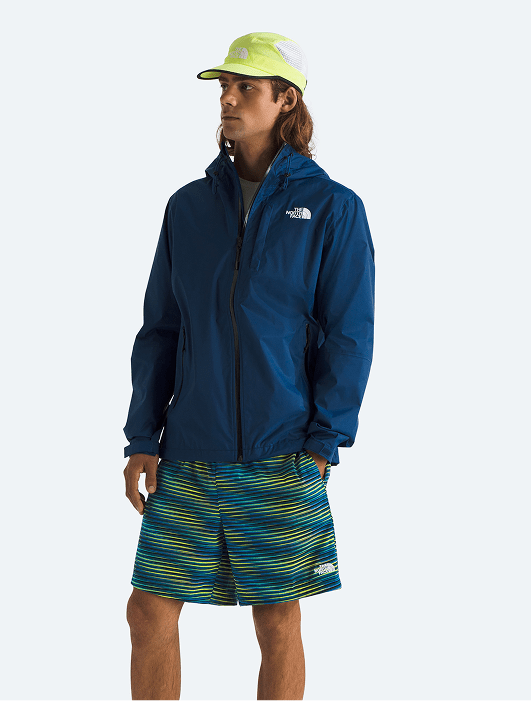 A man modeling a blue rain jacket and shorts