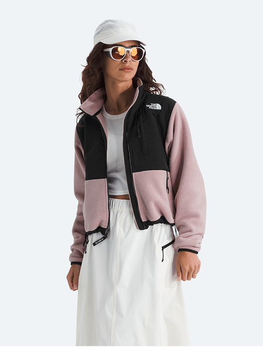 A woman modeling a full-zip fleece and white skirt