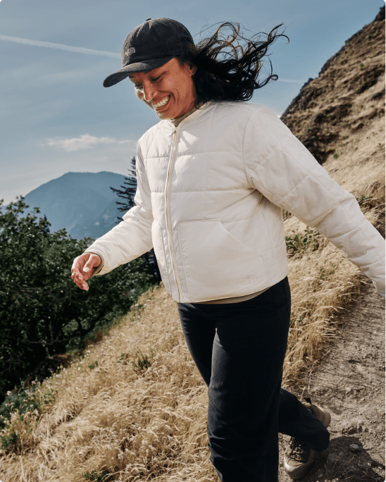 A man and woman walking down a hill wearing Lhotse lightweight jackets