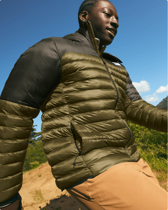 A man wearing the Terra Peak Jacket in a field