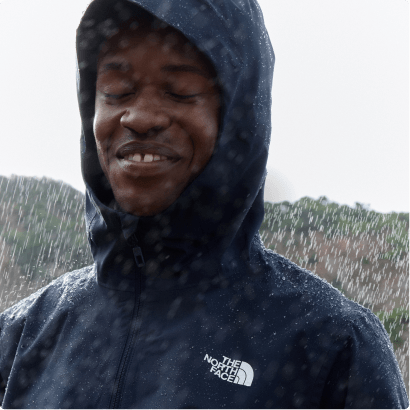 A man wearing a rain jacket smiling in the rain