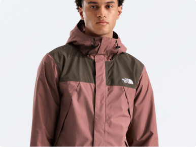 A man modeling a blue rain jacket and shorts