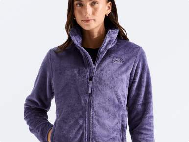 A woman modeling a full-zip fleece and white skirt