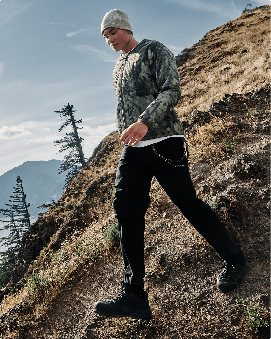 A man walking down a mountain wearing the Lhotse lightweight jacket