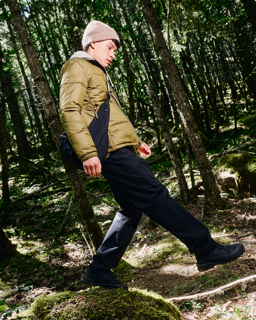A man walking in the wilderness wearing a green Nuketo jacket