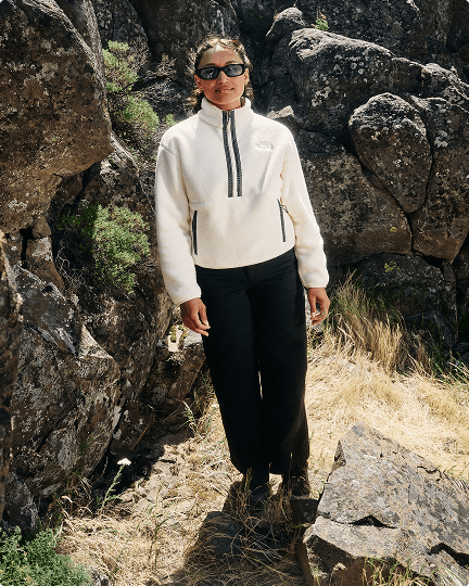 A woman walking wearing a white Fleeski 1/2 Zip Fleece