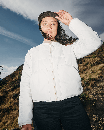 A woman on a mountain wearing a white Lhotse jacket