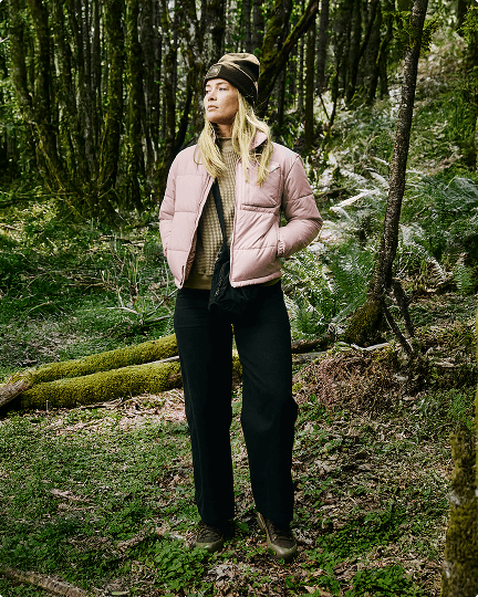 A Woman in the woods wearing a pink Nuketo jacket