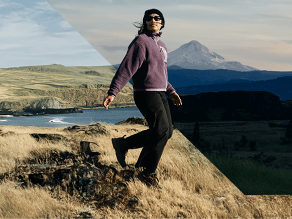 Woman standing in a field wearing a purple fleece