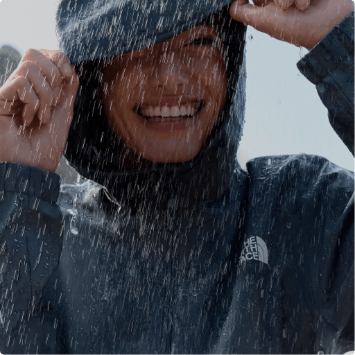 A man wearing a rain jacket smiling in the rain