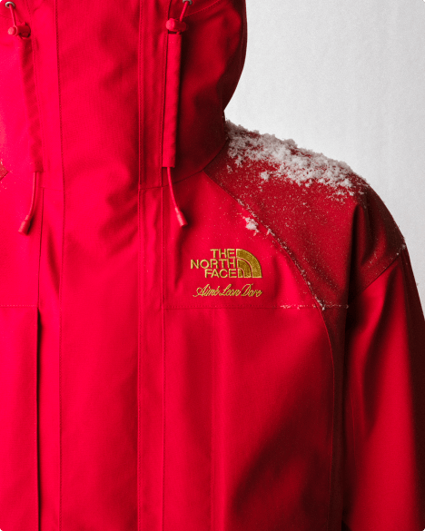 Close-up of red jacket with snow on the right shoulder.