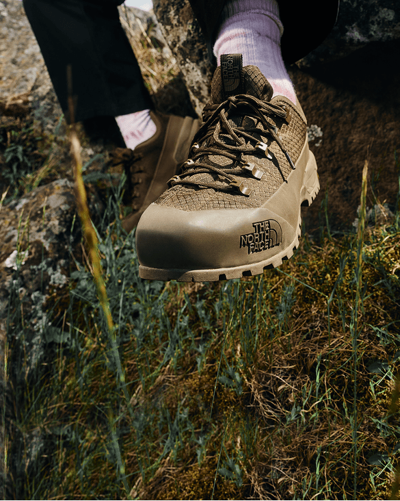 Closeup shot of a khaki The North Face boot in the woods.
