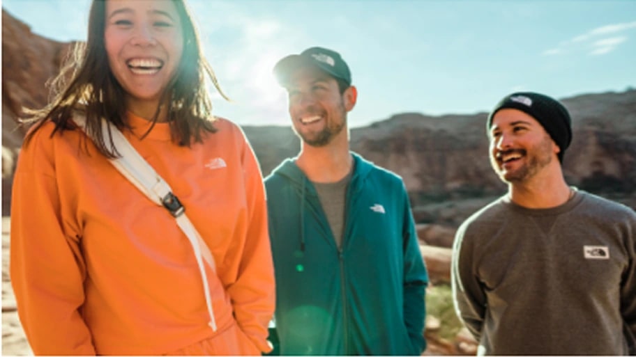 A group of hikers pose for a photo on a trail.