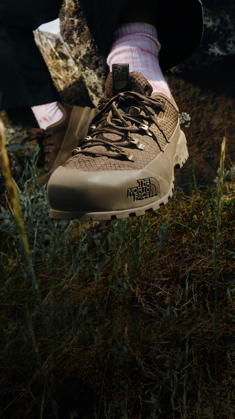Closeup shot of a khaki The North Face boot in the woods.