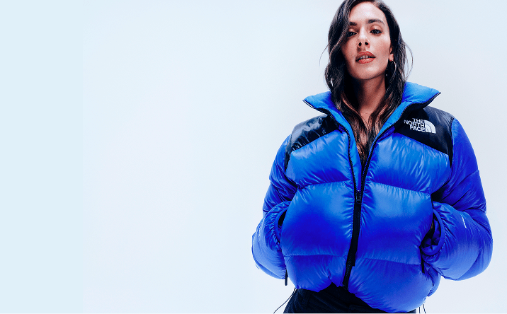 A member of the DJ trio Las Flaquitas is wearing a blue Pertex Nuptse jacket in its original form. 