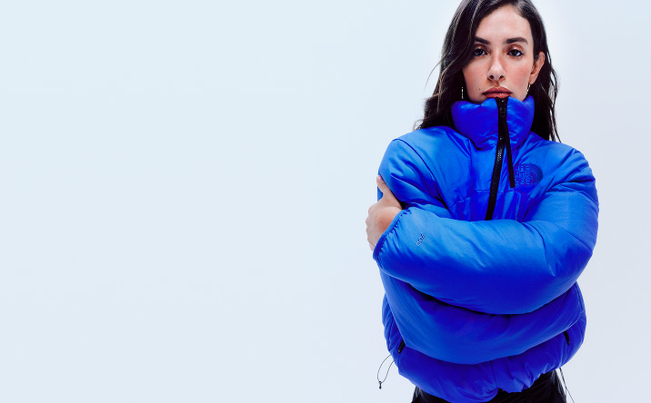 A member of the DJ trio Las Flaquitas is wearing a blue Pertex Nuptse jacket in its reversible form. 