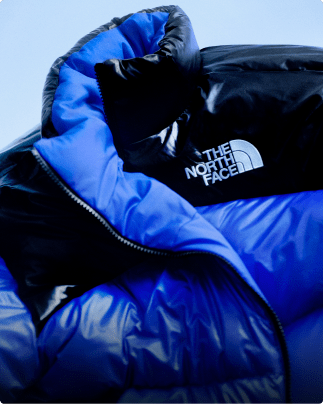A closeup of the collar of a blue Pertex Nuptse jacket.