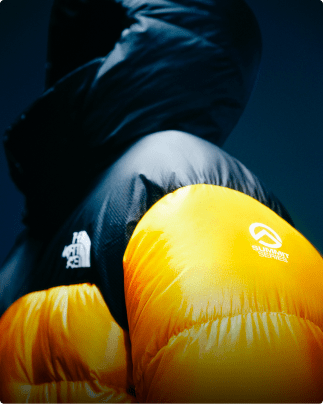 A closeup of the shoulder of a yellow Summit Nuptse jacket.