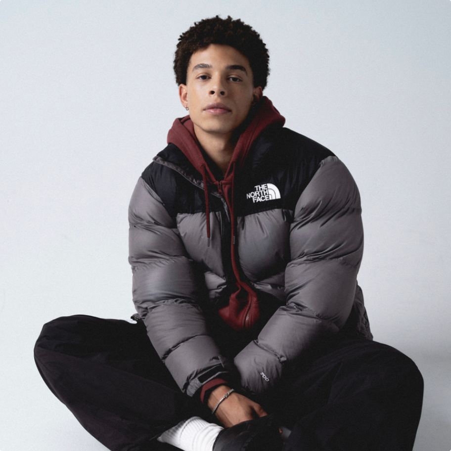 A person standing down posing wearing a North Face jacket.